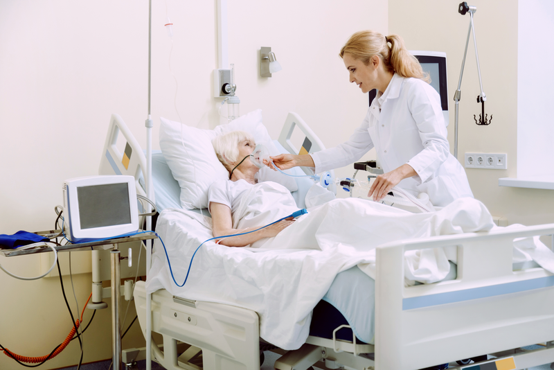 Kvinde på båre på vej ind i ambulance der modtager smertelindring